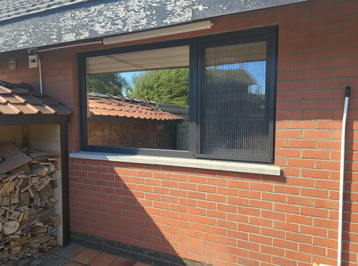 New dark-framed lounge window with ventilated flyscreen panel