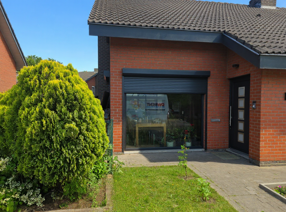 Dark front door and roller-shuttered picture window on a Leuven brick townhouse