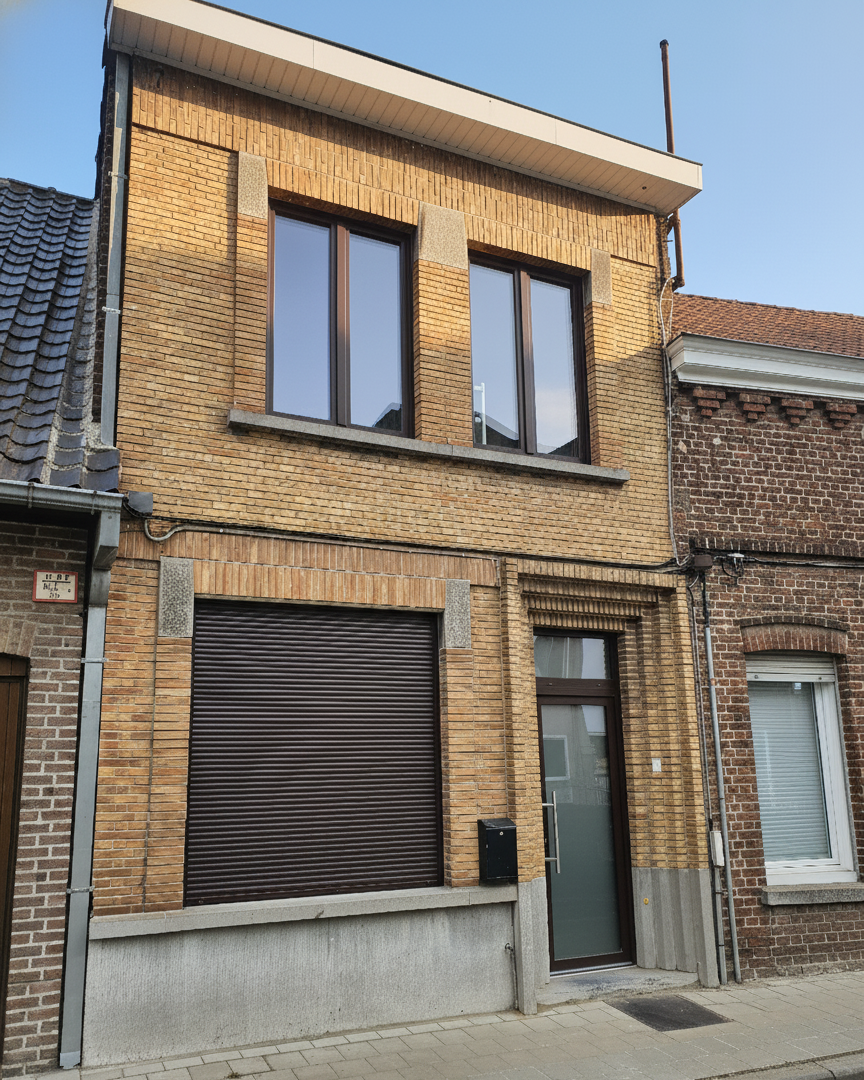 Antwerp yellow-brick townhouse with dark brown windows and roller shutter